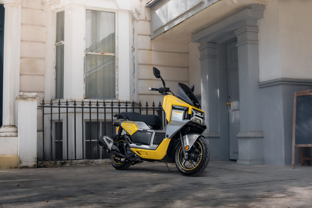 Primer plano de la LETBE Mecha 125 en color Amarillo Ettore, mostrando su frontal futurista, iluminación LED agresiva y líneas de diseño ciberpunk.