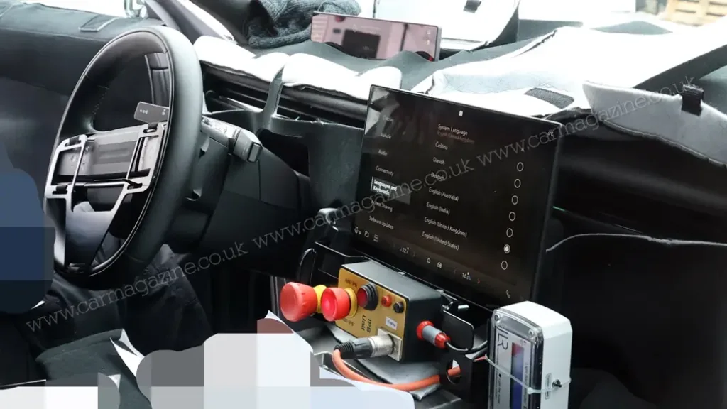 Interior del Range Rover Velar Electric con pantallas de diagnóstico y una gran pantalla central flotante