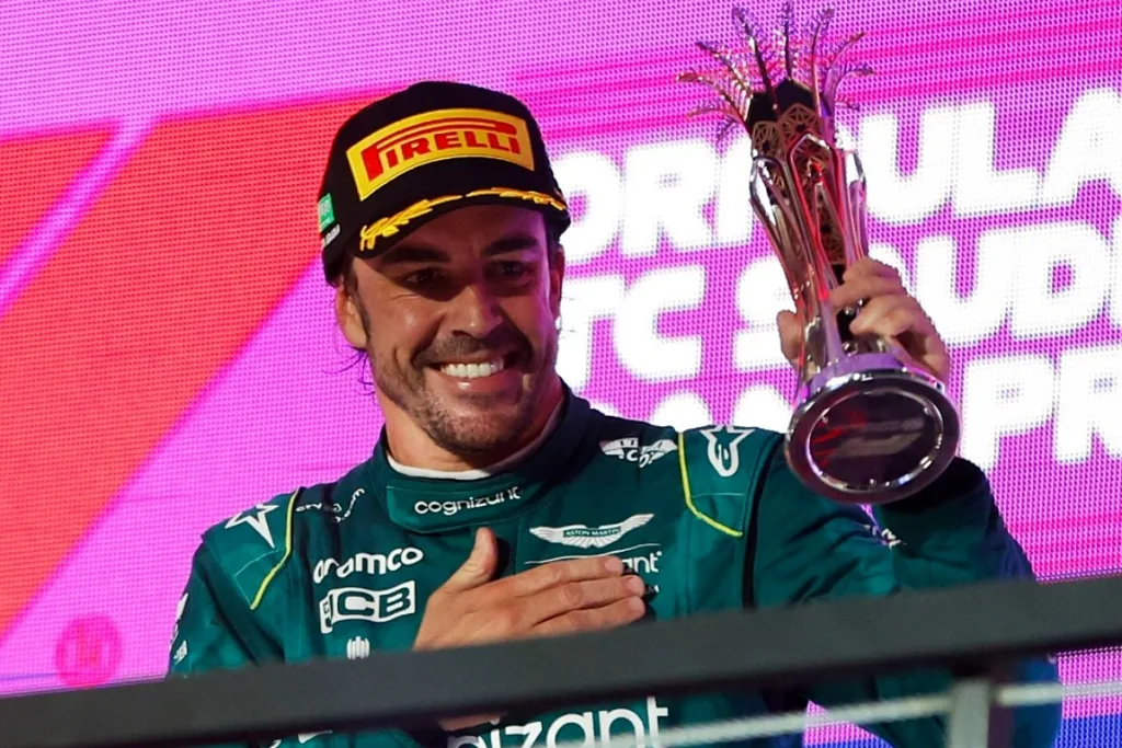 Fernando Alonso posando con el trofeo recuperado de madrugada en el hospitality de Aston Martin